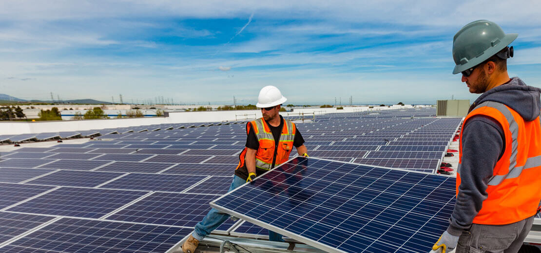 Workers carrying solar panels